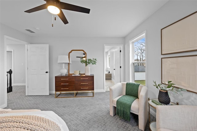 bedroom with connected bathroom, light colored carpet, and ceiling fan