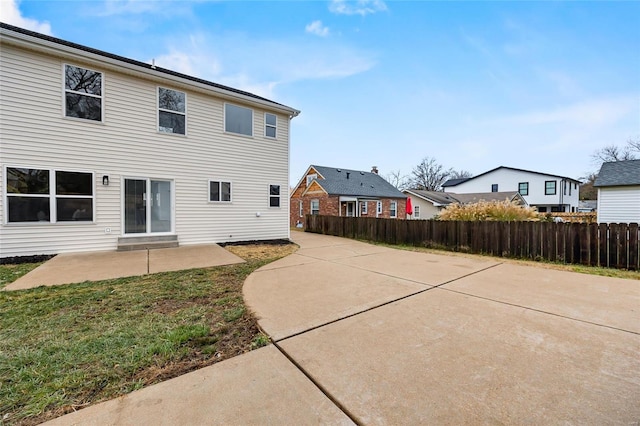 rear view of house with a patio area and a lawn