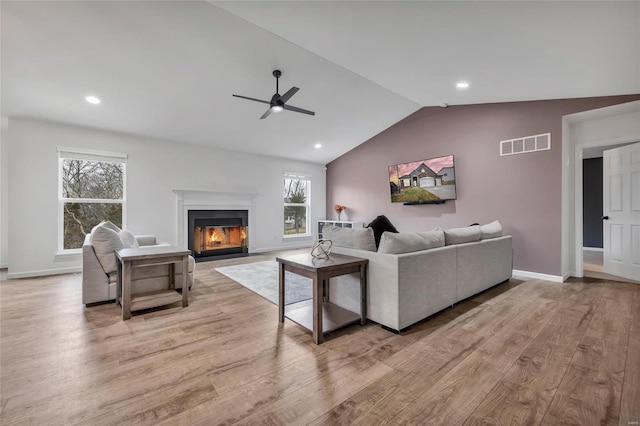 living room with light hardwood / wood-style flooring, vaulted ceiling, and ceiling fan