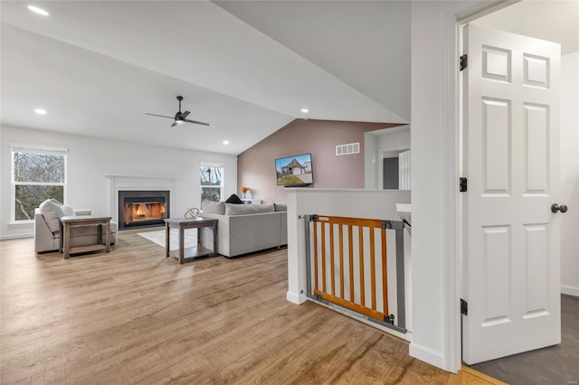 living room featuring light hardwood / wood-style floors, ceiling fan, and lofted ceiling