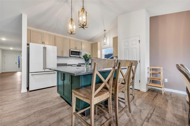 kitchen featuring decorative light fixtures, white refrigerator, light hardwood / wood-style floors, and light brown cabinets