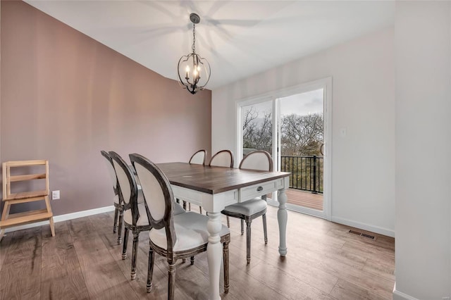 dining space featuring an inviting chandelier and light hardwood / wood-style flooring