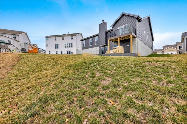 rear view of property featuring a lawn and a balcony