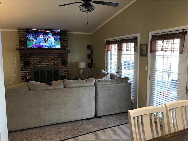 living room with ornamental molding, ceiling fan, light hardwood / wood-style flooring, a fireplace, and lofted ceiling