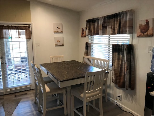 dining area with plenty of natural light and dark hardwood / wood-style floors