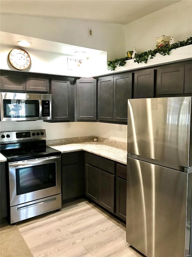 kitchen featuring appliances with stainless steel finishes, light hardwood / wood-style flooring, and dark brown cabinets