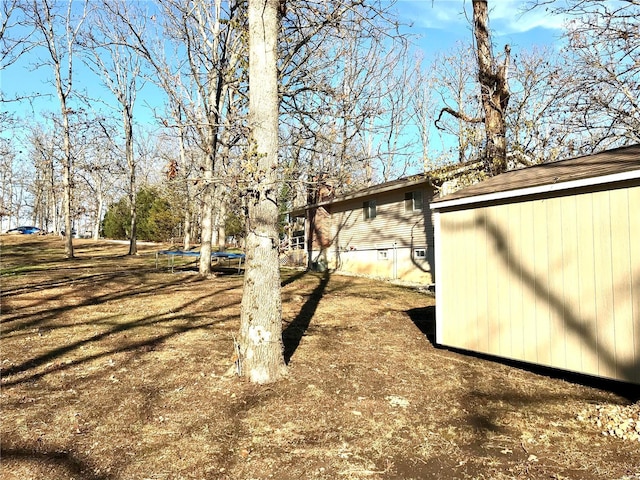 view of yard with a storage unit and a trampoline