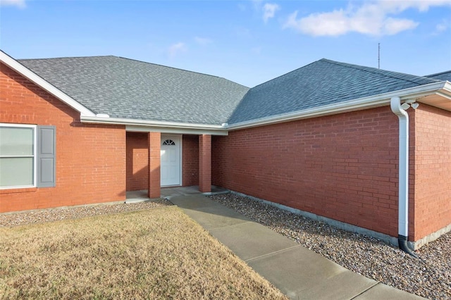 entrance to property with a lawn