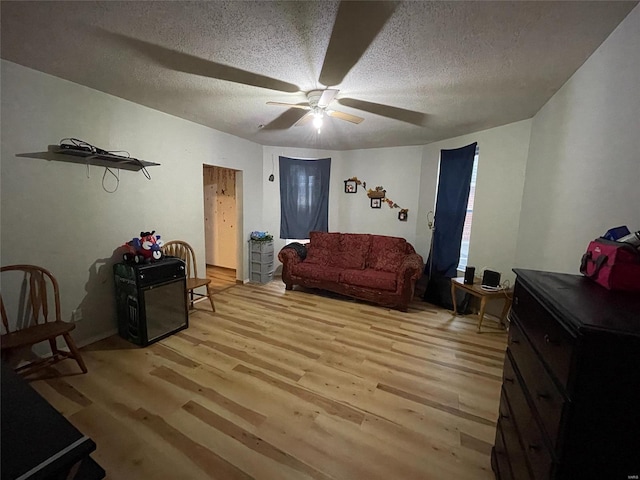 sitting room with a textured ceiling, light hardwood / wood-style flooring, and ceiling fan