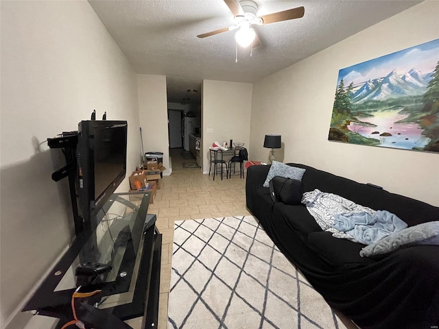 living room with ceiling fan and a textured ceiling