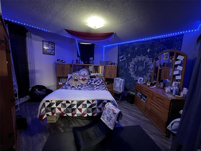 bedroom featuring hardwood / wood-style floors and a textured ceiling