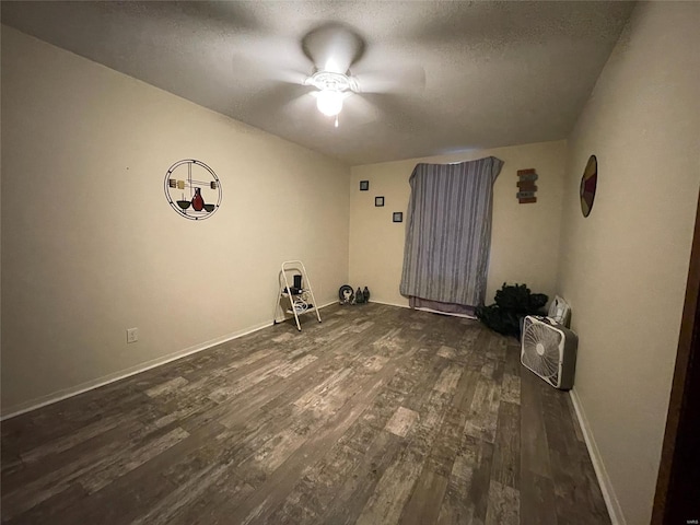 unfurnished room with a textured ceiling, ceiling fan, and dark hardwood / wood-style floors