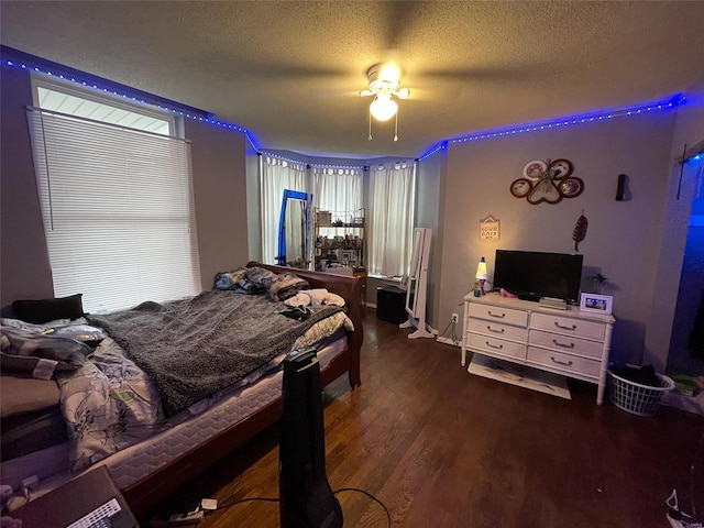 bedroom featuring dark hardwood / wood-style floors, ceiling fan, a textured ceiling, and multiple windows