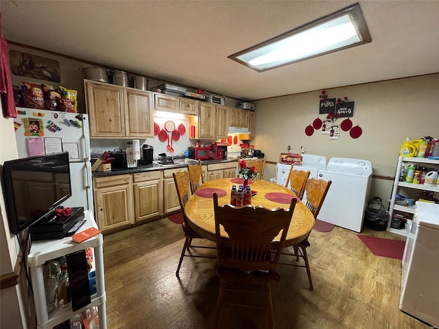 kitchen with hardwood / wood-style flooring, sink, and independent washer and dryer