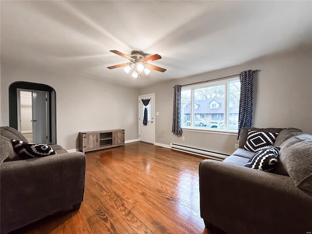 living room featuring ceiling fan, wood-type flooring, and a baseboard heating unit