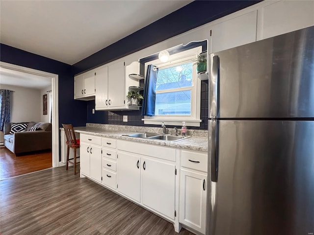 kitchen with white cabinetry, sink, stainless steel refrigerator, and dark wood-type flooring