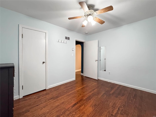 unfurnished bedroom with ceiling fan and dark wood-type flooring