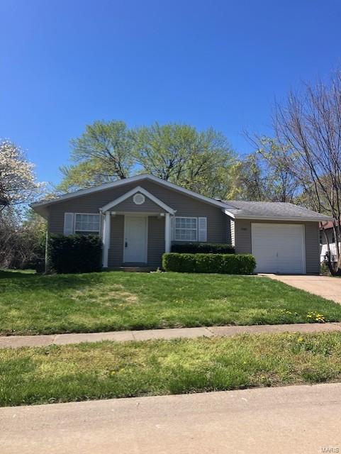 ranch-style home featuring driveway, a front yard, and a garage