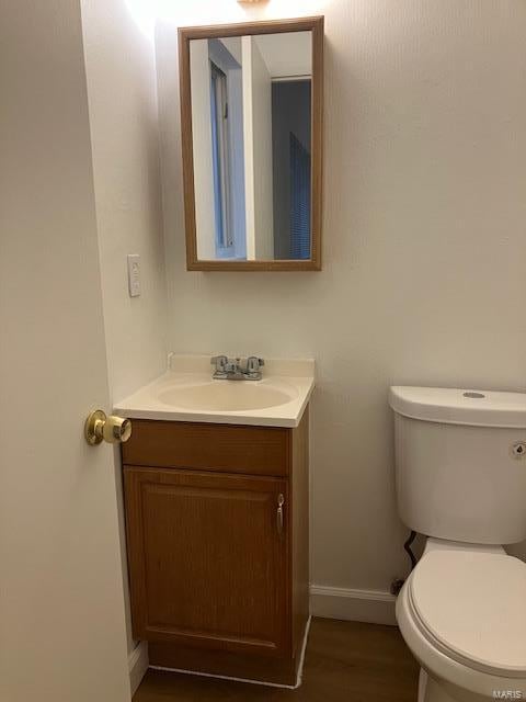 bathroom with vanity, baseboards, toilet, and wood finished floors