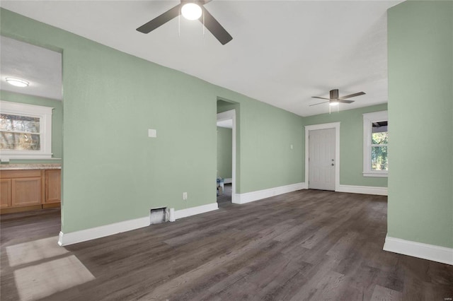 unfurnished living room with ceiling fan and dark hardwood / wood-style flooring