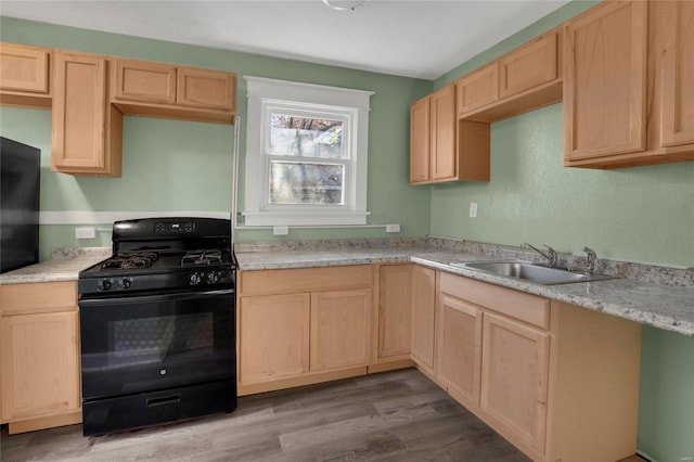 kitchen featuring light brown cabinets, sink, light hardwood / wood-style flooring, and black range with gas cooktop