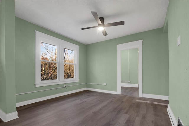 empty room with ceiling fan, dark wood-type flooring, and a textured ceiling