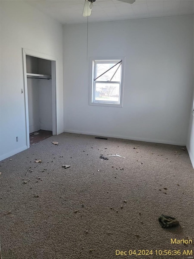 unfurnished bedroom with ceiling fan, a closet, and carpet floors