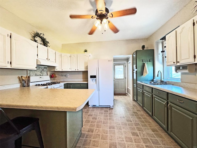 kitchen with white cabinetry, ceiling fan, white appliances, and kitchen peninsula