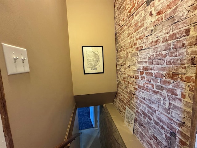 interior space featuring tile patterned floors and brick wall