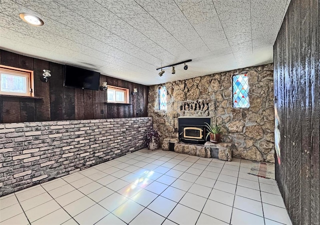 unfurnished living room with a wood stove and light tile patterned floors