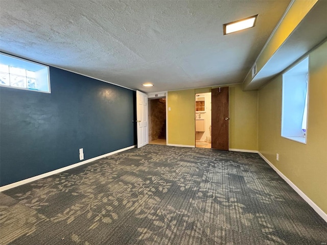 basement featuring carpet flooring and a textured ceiling