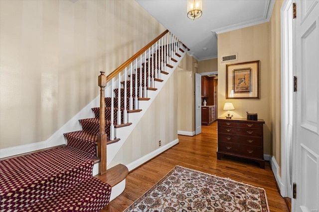 stairway featuring crown molding and hardwood / wood-style floors