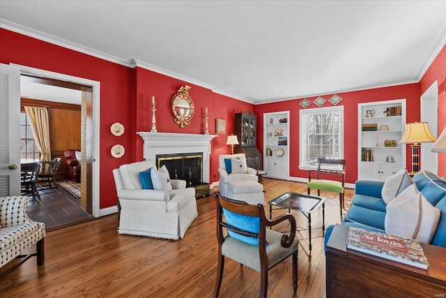 living room featuring built in shelves, ornamental molding, and wood-type flooring