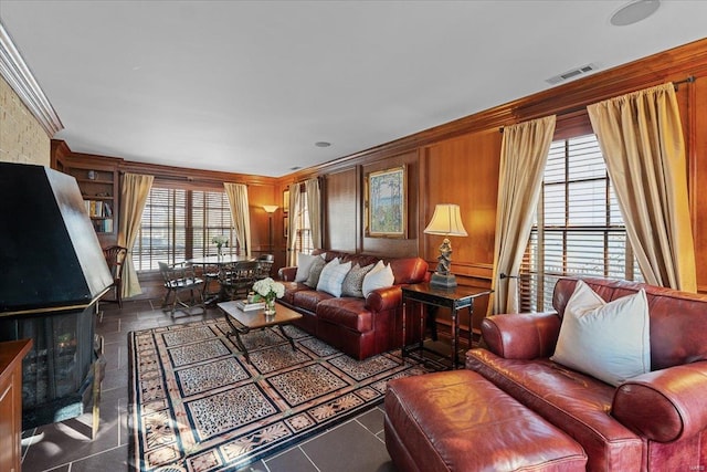 living room with crown molding and wood walls