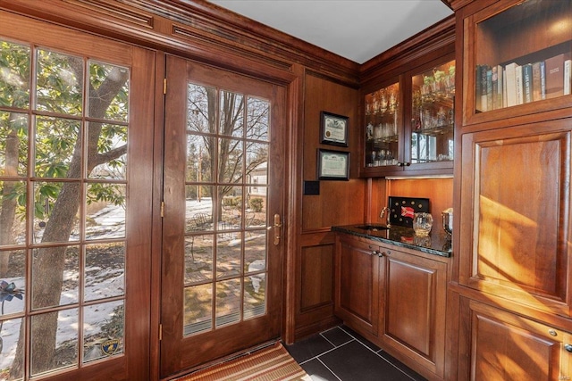 doorway featuring a healthy amount of sunlight, bar, and wood walls