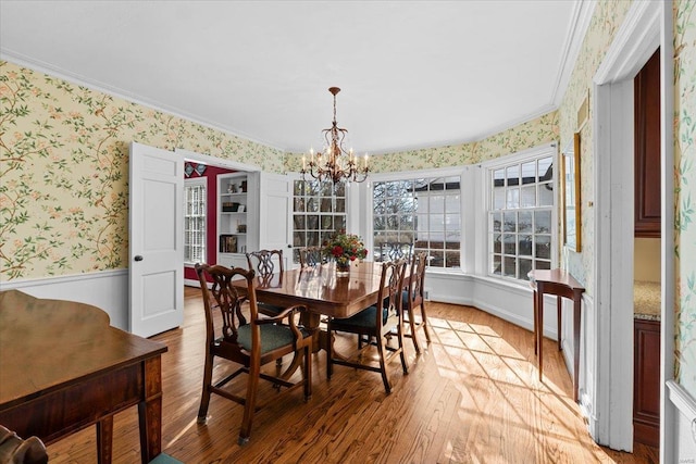 dining area featuring ornamental molding, a chandelier, and light hardwood / wood-style flooring