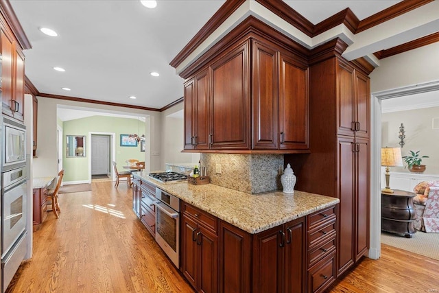 kitchen with backsplash, light wood-type flooring, ornamental molding, and appliances with stainless steel finishes