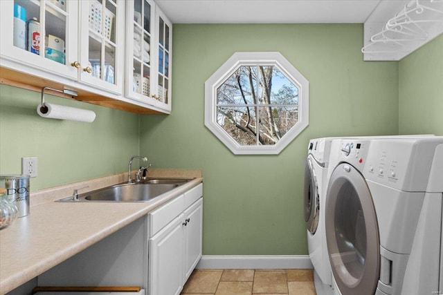 washroom with sink, washing machine and dryer, and cabinets