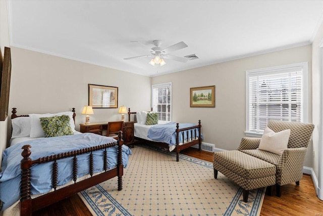 bedroom featuring multiple windows, wood-type flooring, crown molding, and ceiling fan