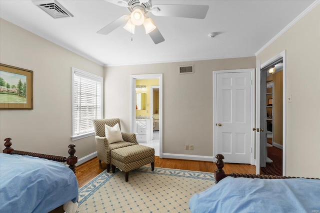 bedroom featuring crown molding, hardwood / wood-style floors, ensuite bathroom, and ceiling fan