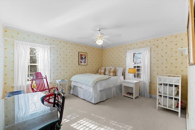 bedroom with ceiling fan, light colored carpet, ornamental molding, and multiple windows