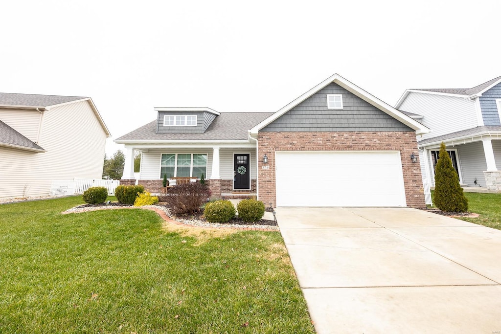 craftsman inspired home with a front yard and a garage