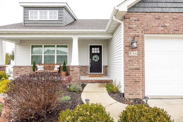 doorway to property with a porch and a garage