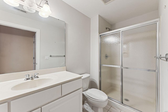 bathroom with toilet, tile patterned flooring, a shower with shower door, and vanity