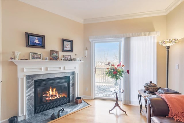 sitting room featuring hardwood / wood-style floors, a high end fireplace, and crown molding