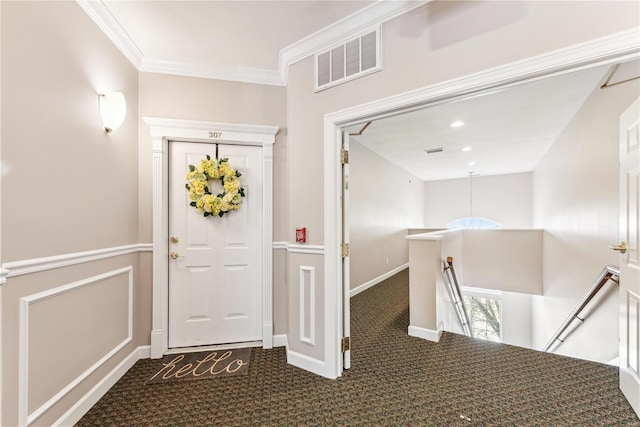 foyer entrance with ornamental molding and carpet flooring