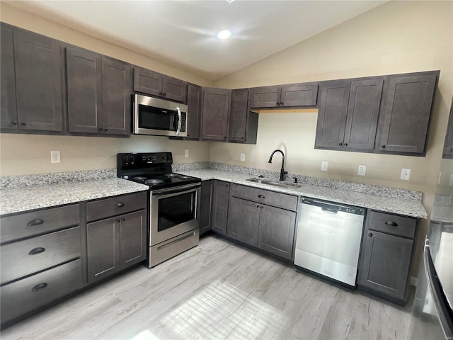 kitchen featuring dark brown cabinets, stainless steel appliances, sink, light hardwood / wood-style flooring, and lofted ceiling