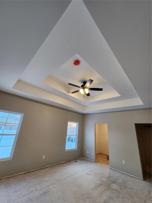 interior space featuring ceiling fan and a tray ceiling