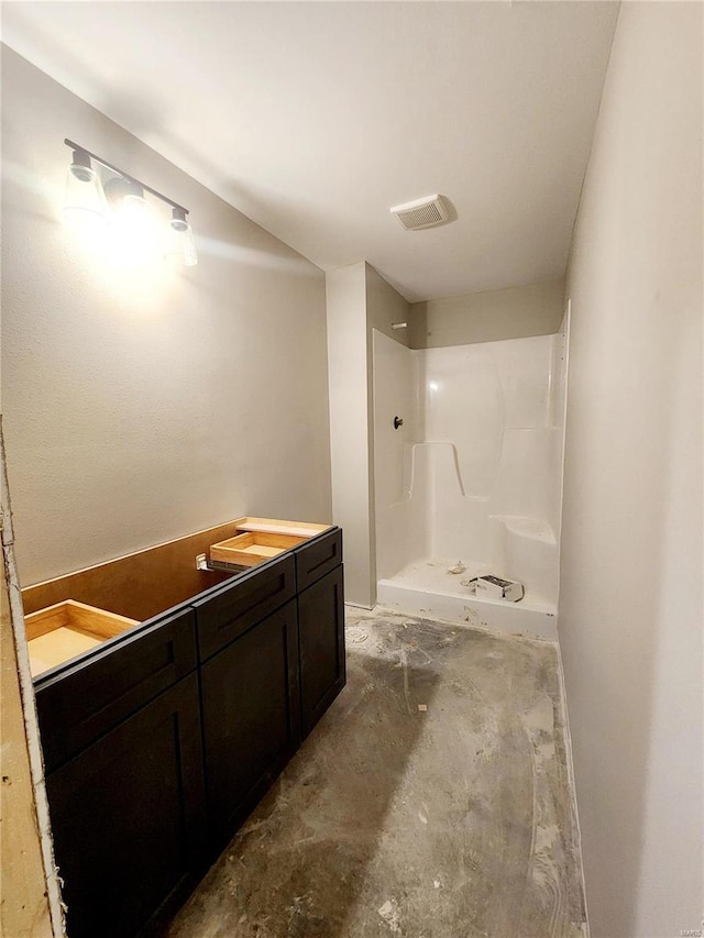 bathroom with vanity, a shower, and concrete flooring