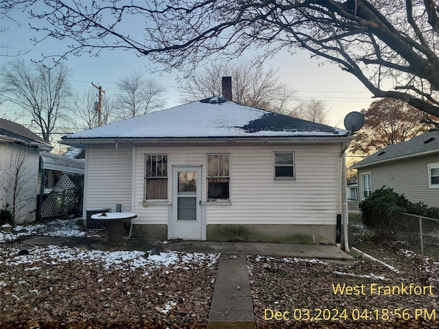 snow covered rear of property with cooling unit